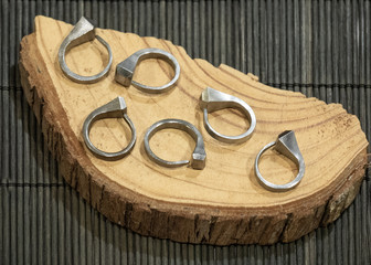 curved nails turned into rings, exposed on a wooden plate