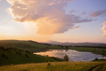 Russian green hills and meadows in Altai. Aya Lake for tourists. The sun and sunset of the day. Summer and grass. Nature travel