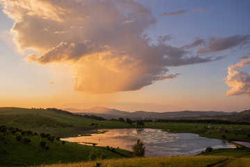 Russian green hills and meadows in Altai. Aya Lake for tourists. The sun and sunset of the day. Summer and grass. Nature travel