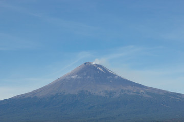 Active volcano Popocatepetl, fumarole over blue sky
