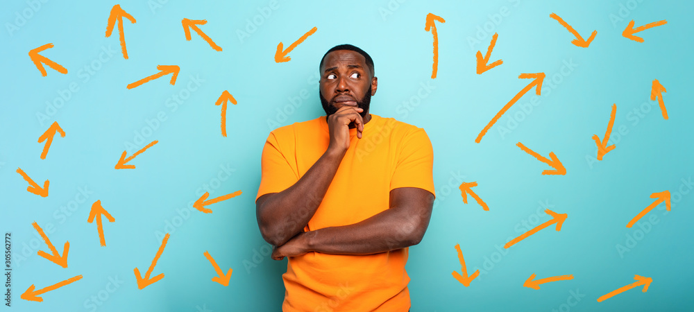 Wall mural confuse and pensive expression of a boy with many arrows to follow. cyan colored background