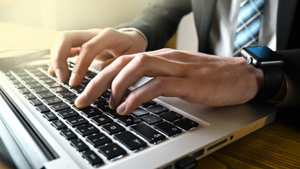 Obraz na płótnie Canvas Business man typing on laptop keyboard