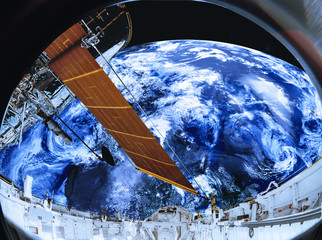 Satellite telescope near to far water planet with atmosphere somewhere in space. View from space station porthole. Science fiction. Elements of the image were furnished by NASA