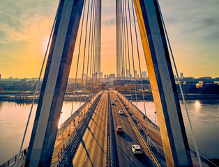 Beautiful panoramic aerial drone sunset view to Warsaw city center with skyscrapers and Swietokrzyski Bridge (En: Holy Cross Bridge) - is a cable-stayed bridge over the Vistula river in Warsaw, Poland - obrazy, fototapety, plakaty