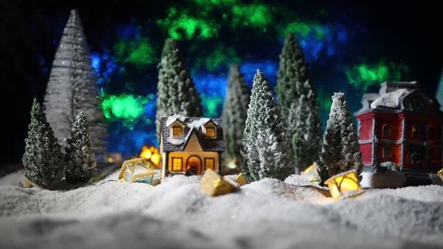Christmas and New Year holidays concept. Little decorative cute small houses in snow at night. Traditional holiday attributes on snow. Creative artwork decorations. Empty space for your text