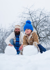 Happy father and son making snowball in the snow. Handmade funny snow man. Happy father and son play on winter Christmas time. Happy winter time. Father and son in snow. Fathers day.