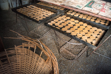 bandejas negras con galletas recien horneadas en una panadería sobre canastos de metal y mimbre 