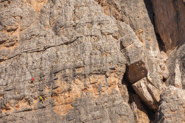 Rock climbers in action over a vertical cliff in the Cinque Torri area in Dolomites