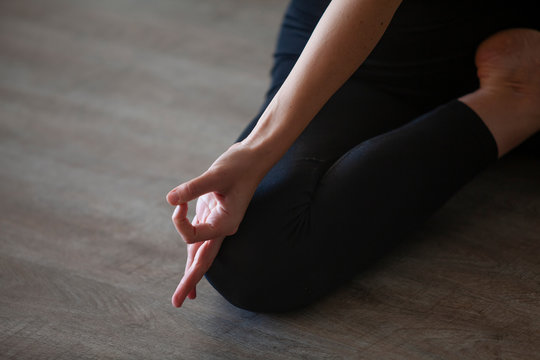Close up on womans hand doing Jnana Mudra as she practices Bharadvajasana pose