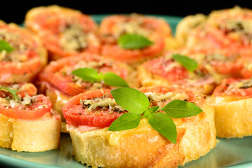 bruschetta with tomato, parmesan, olive oil, ham and oregano