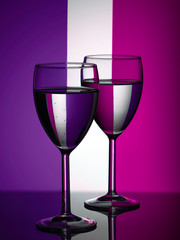 Two wine glasses silhouette full on colored background. Alcohol beverage.