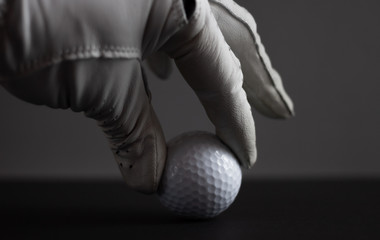 hand in glove keep golf ball on black background