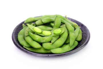 Edamame beans on Japanese black earthenware dish Isolated on white background. Steamed salted soybeans, the popular appetizer of Japanese cuisine.