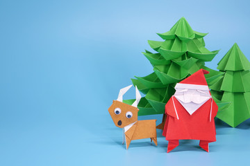 Origami paper art : Santa Claus, reindeer and Christmas tree for greeting season of Christmas and New year. Copy space