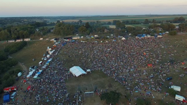 Lots of people crowd celebrate. Ethnic festival holiday. Folk feast concert in the countryside in a rural natural lake landscape. Aerial survey 