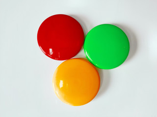 Round colored magnetic markers pinned to a white board with close up