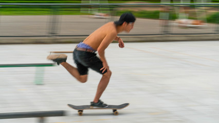A young skateboarder pushes his foot out on his skateboard in the skatepark 