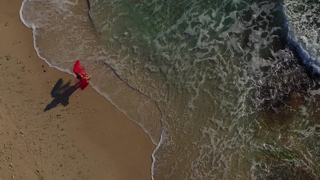 a girl in a red dress runs and dances on the beach es Trenc Majorca Spain