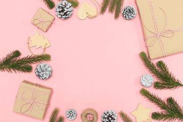 2020 New year composition. Stylish decor concept, christmas wooden toy, kraft paper gift box, fir cones branches on pink backdrop. Flat lay, top view, copy space. Background for postcard, for desktop
