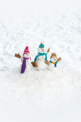 Funny group of snowmen family - New Year greeting card. New Year banner. Snowman group on the white snow background.