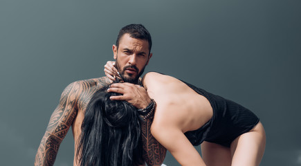 Happy to be in love. Sexy and fit woman and hugging handsome man with tattoo. Passionate woman and...