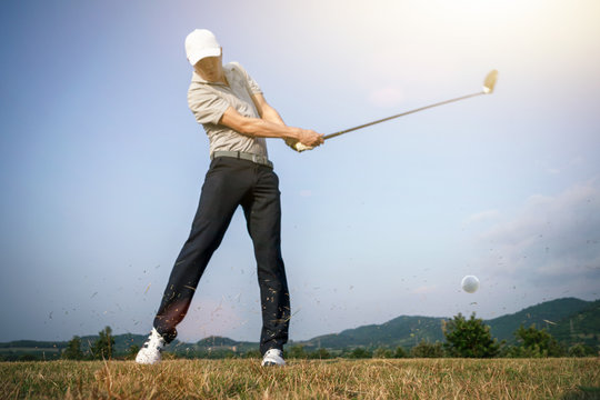 Blurred images of golfers who hit golf balls with scattered grass.