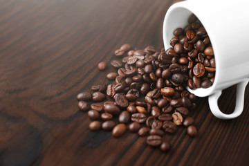 Coffee in cup and coffee beans on wooden background