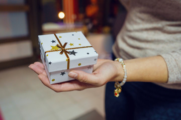 Close up on female women's hand girl holding a box with gift present giving or receiving surprise