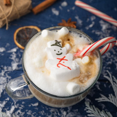 Christmas and New Year. Marshmallow snowman in hot latte in a mug. In the square for Instagram