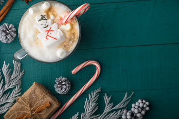 Christmas composition, hot coffee with marshmallows and a New Year`s snowman. Horizontal photo, with space
