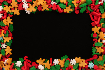 Christmas candies for pastry decoration on a blackboard. Directly above. Copy space for your text.