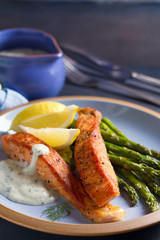 Salmon fish fillet with asparagus and creamy garlic sauce