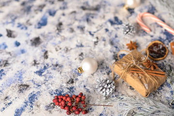 Christmas composition. Gift, cones with Christmas tree and Christmas tree branches and caramel. Background for New Year and Christmas. Horizontal frame with space.