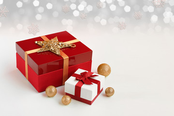 Red gift box wrapped with golden ribbon and white gift box wrapped with red ribbon on Christmas ornaments. Isolated on white background and copy space. 