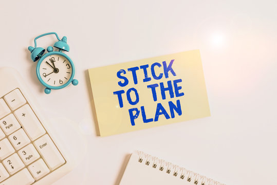Conceptual hand writing showing Stick To The Plan. Concept meaning To adhere to some plan and not deviate from it Follow Keyboard with empty note paper and pencil white background