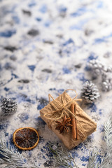 Christmas composition. Gift, cones from the Christmas tree and Christmas tree branches. Background for the New Year and Christmas. Vertical frame.