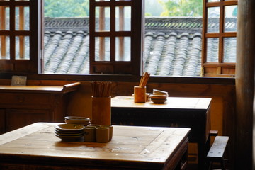Chopsticks, cup and bowl on the wooden table, with oriental looking background,