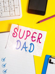 Writing note showing Super Dad. Business concept for Children idol and super hero an inspiration to look upon to Crumpled white paper on table paper clips clock mobile and pc keyboard