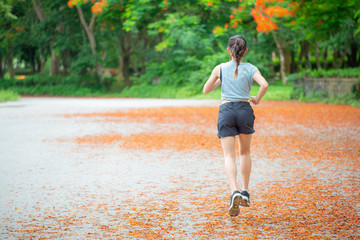 Back view of young runner woman running in the park. Running is a great way to help improve cardiovascular health, burns calories and can build strength. 