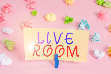 Word writing text Live Room. Business photo showcasing the room in a house or apartment that is used for relaxing in Colored crumpled papers empty reminder pink floor background clothespin