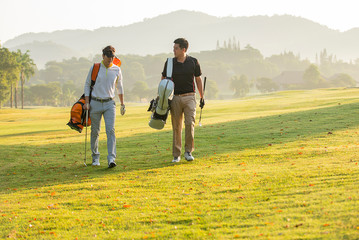 golfer holding golf clup walking on green