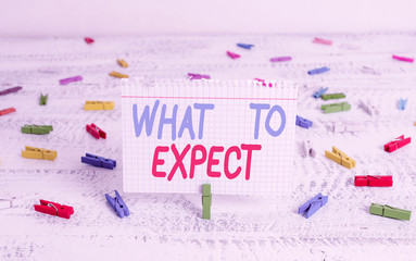 Handwriting text writing What To Expect. Conceptual photo Confusion about the belief of what will happen in future Green clothespin white wood background colored paper reminder office supply
