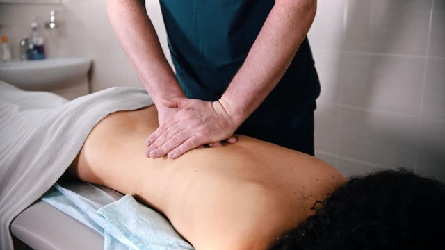 Chiropractic treatment - the doctor giving the patient a massage - pushing on the back with hands