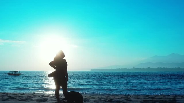 The tropical island of Hawaii - Tourist enjoying the beautiful sunrise over the Pacific Ocean with clear blue skies with a boat floating over the ocean - Wide Shot