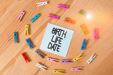 Writing note showing Birth Life Date. Business concept for Day a baby is going to be born Maternity Pregnancy Give life Colored clothespin papers empty reminder wooden floor background office