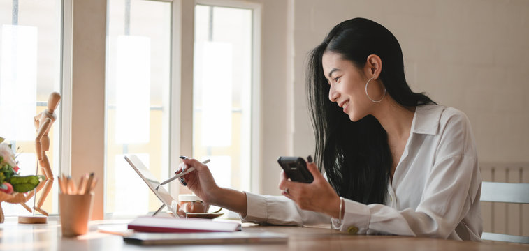 Young professional businesswoman working on her project with digital tablet in comfortable office
