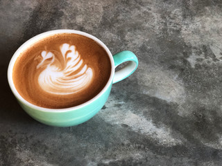 Swan shape latte art coffee in white and green cup on cement floor with natural light ; love coffee, Top view and copy space.