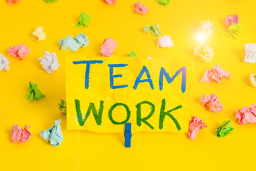 Handwriting text writing Team Work. Conceptual photo Combined action of a group Workgroup cooperation collaboration Colored crumpled papers empty reminder white floor background clothespin