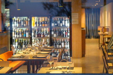 View of a European cafe, restaurant in the evening through stained glass. The interior of a cozy cafe without customers. Shadows from the trees on the window.