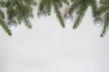 Christmas or new year composition.Top view,four silver balls and Christmas tree branches on white background, copyspace.